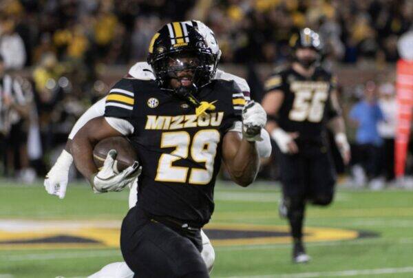 Missouri Tigers running back number 29 carries the ball down the field during a college game.