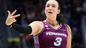 Female basketball player in Toronto jersey #3 extending arm in a dynamic pose during a game.
