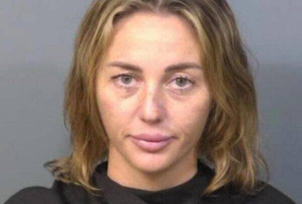 Mugshot of a woman with shoulder-length light brown hair and a neutral expression against a gray backdrop.