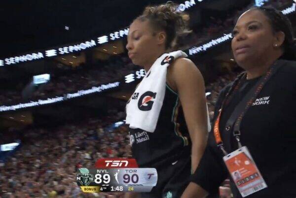 Basketball player with towel over shoulders walks off court as scoreboard shows TOR leading NY 90–89 in a packed arena.