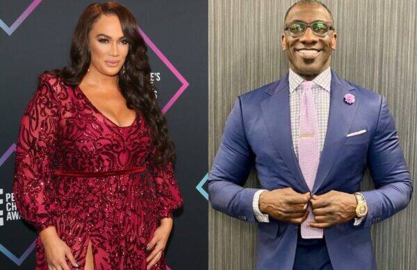 Two people posing at an event: woman in a burgundy sequined gown and man in a blue suit with a pink tie on the right side.