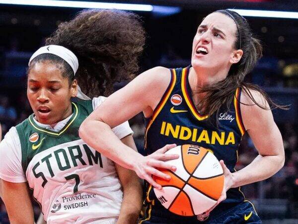 Two female basketball players compete for the ball: an Indiana player in blue drives forward while a Storm defender reaches in.