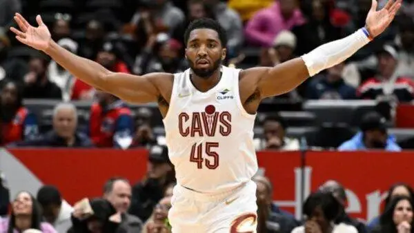 Basketball player in a white Cavs jersey number 45 with arms outstretched during a game on a crowded court.