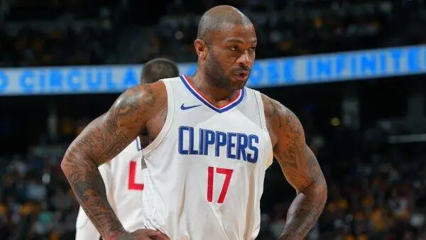 Basketball player in a white Los Angeles Clippers jersey number 17 with hands on hips on the court.