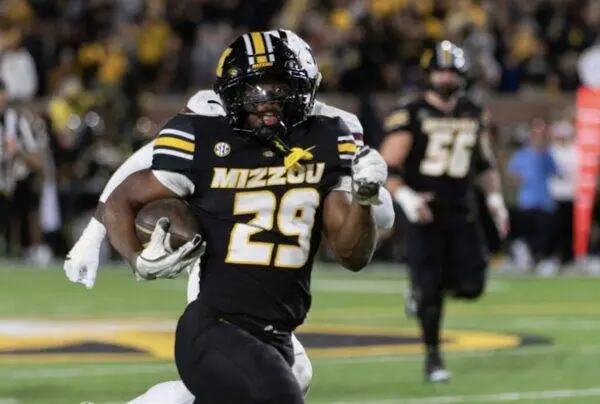 Missouri Tigers running back number 29 carries the ball down the field during a college game.