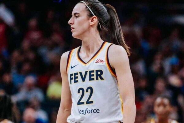 Female basketball player in a white Fever jersey with number 22, standing on the court during a game.