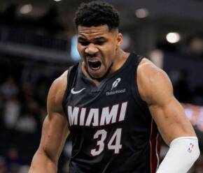 Miami Heat player in jersey #34 shouting intensely on the court during a game, muscles tensed and mouth open in a roar.