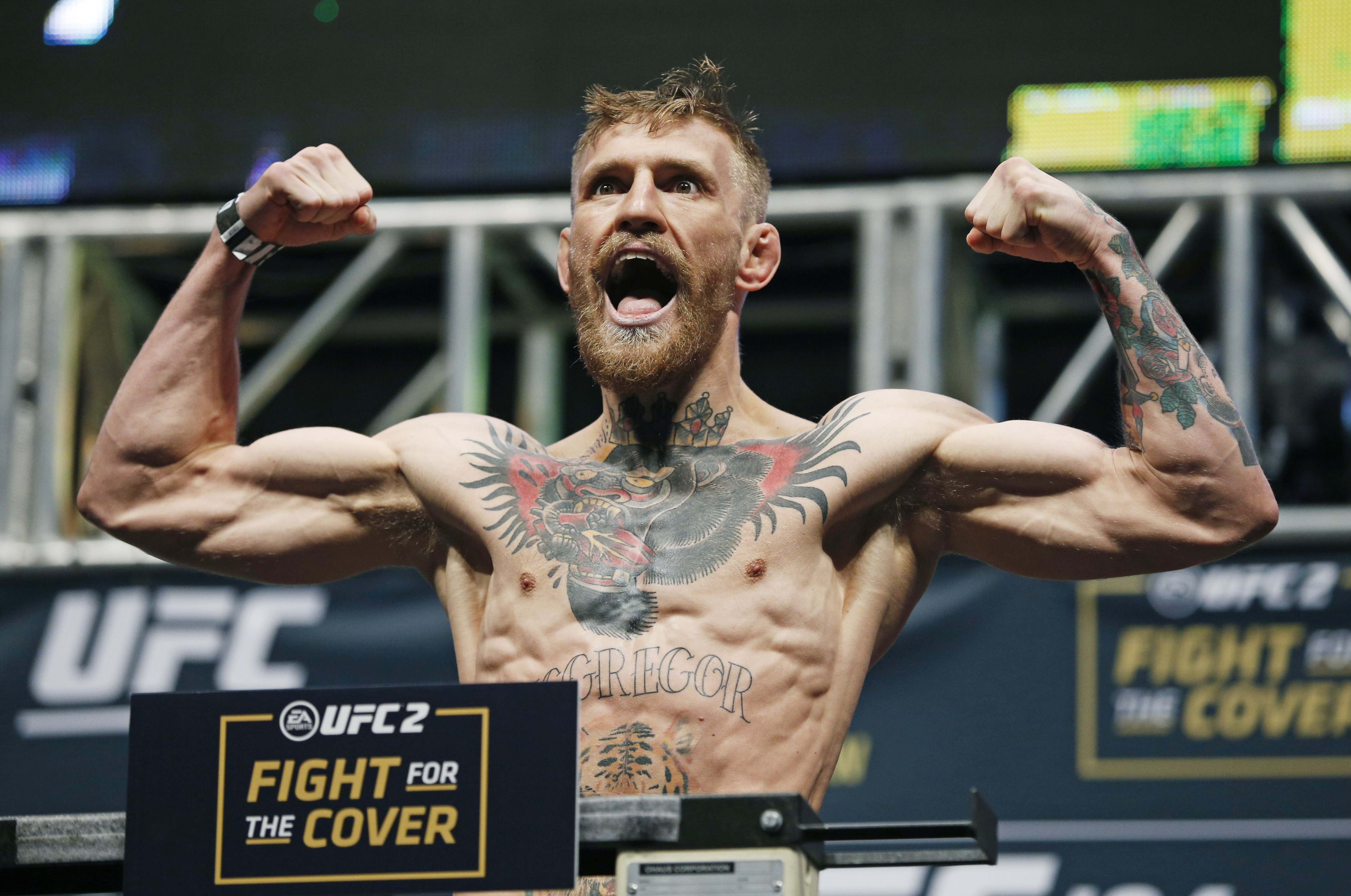Conor McGregor poses on the scale during the weigh-in for UFC 194, Friday, Dec. 11, 2015, in Las Vegas. McGregor is scheduled to fight Jose Aldo in a featherweight championship bout Saturday in Las Vegas. (AP Photo/John Locher)