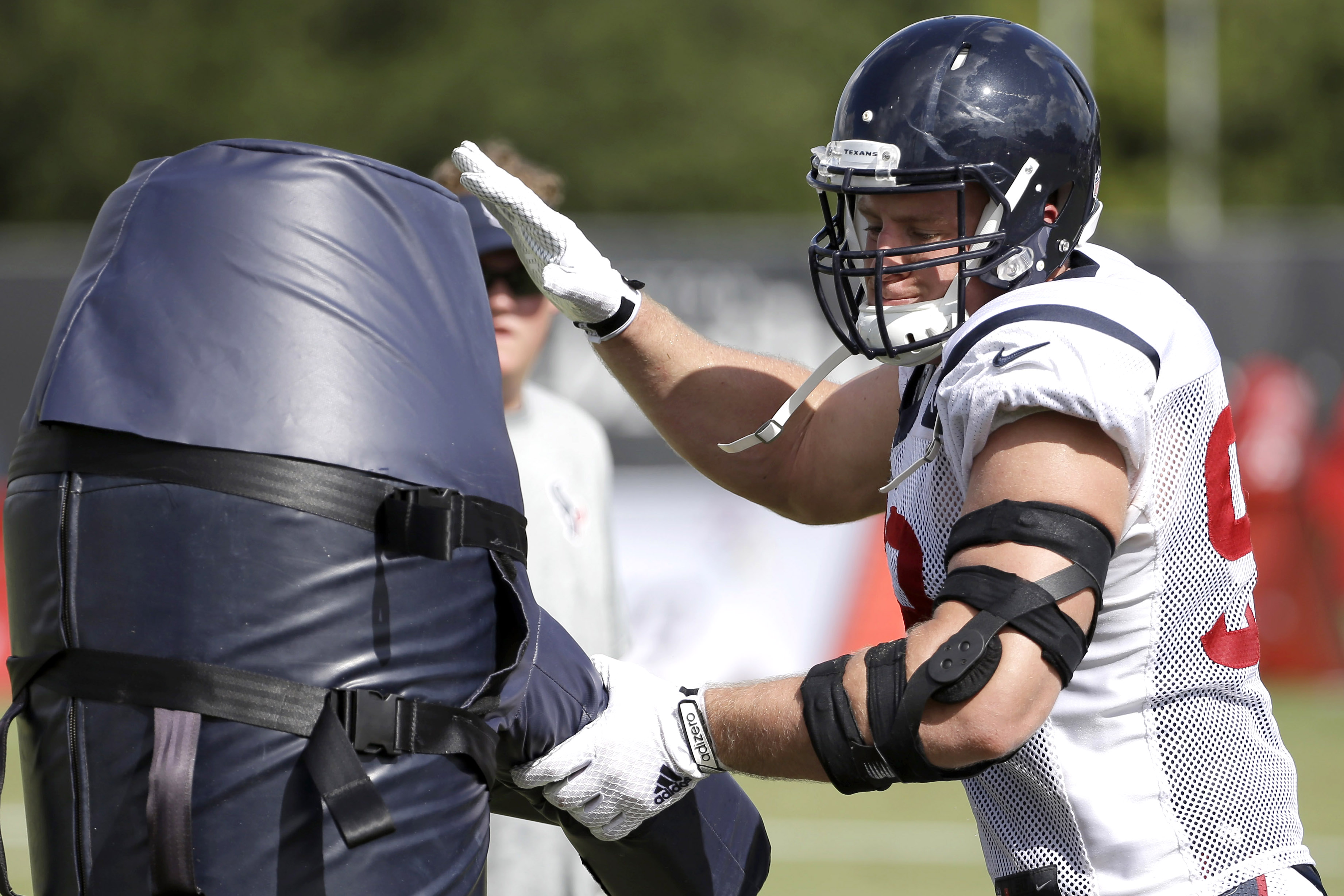 Houston Texans defensive end J.J. Watt hits a tackle dummy  during an NFL football training camp practice Wednesday, Aug. 5, 2015, in Houston. (AP Photo/David J. Phillip)
