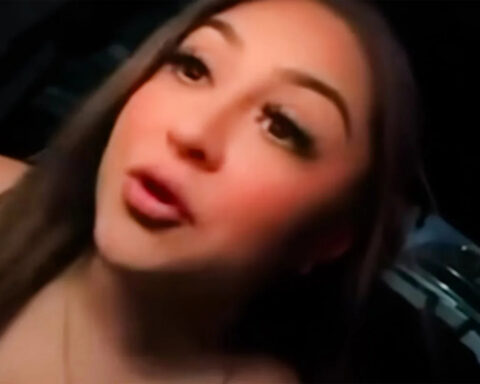 Close-up of a young woman with long dark hair speaking to the camera at night inside a car.3a8 Next to a dark background, she looks toward the lens with lips slightly parted.