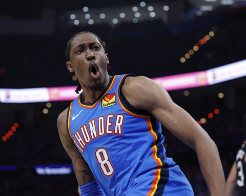 Thunder basketball player in a blue jersey (#8) yells during a game, arm raised in action on the court
