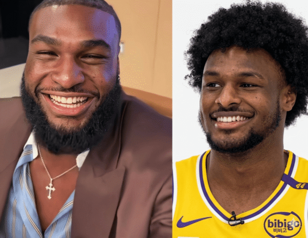 Two men smiling side by side: left in a brown suit and striped shirt with a cross necklace, right in a yellow basketball jersey, both looking happy.