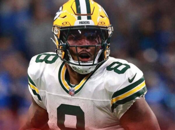 Green Bay Packers football player in a white jersey (number 8) and yellow helmet, running on the field during a game.
