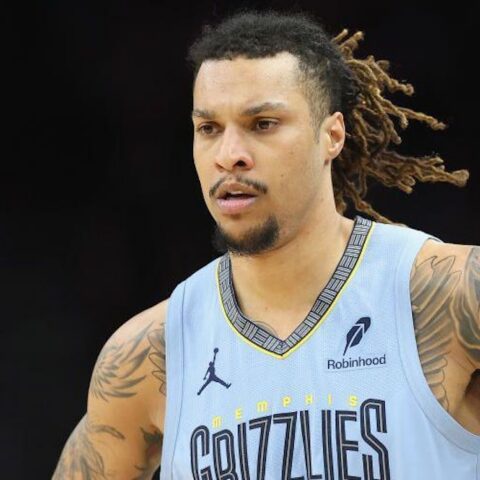 Basketball player in a light blue Memphis Grizzlies jersey with dreadlocks, focused on the court.