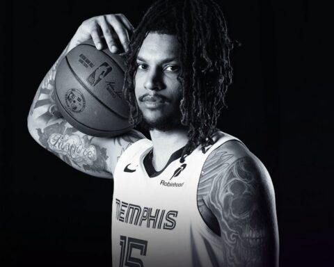 Portrait of a tattooed basketball player with dreadlocks, holding a ball on his shoulder in a Memphis Grizzlies jersey.