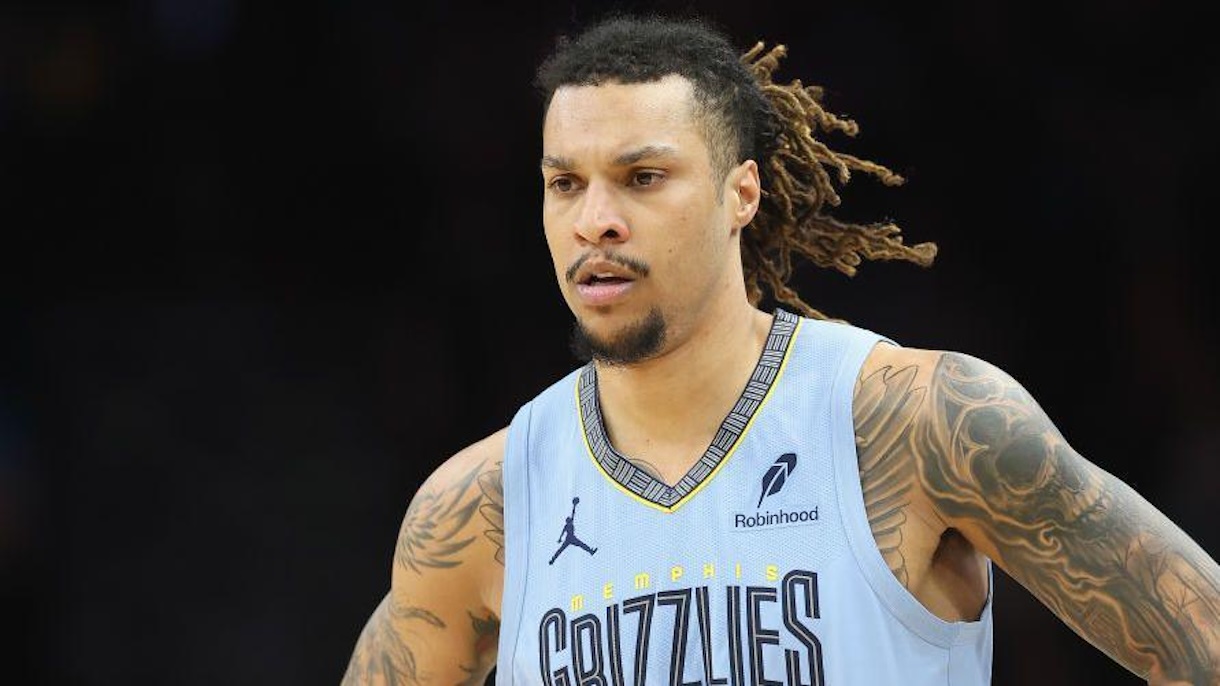 Basketball player in a light blue Memphis Grizzlies jersey with dreadlocks, focused on the court.