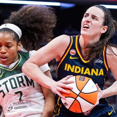 Two female basketball players compete for the ball: an Indiana player in blue drives forward while a Storm defender reaches in.