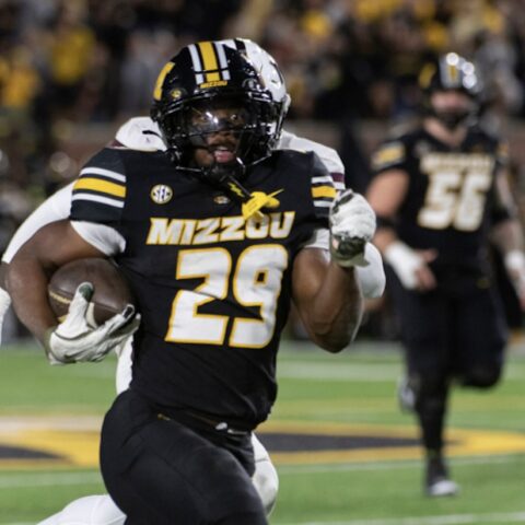 Missouri Tigers running back number 29 carries the ball down the field during a college game.