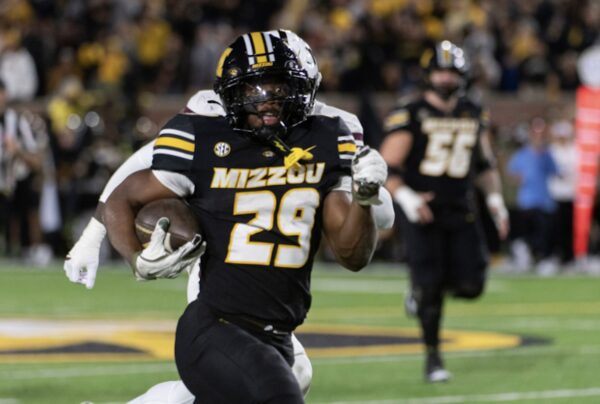 Missouri Tigers running back number 29 carries the ball down the field during a college game.