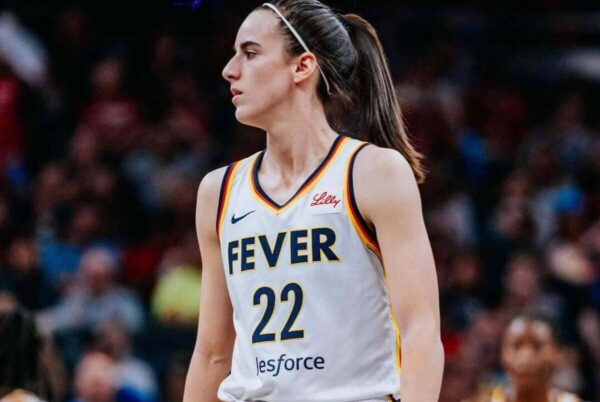 Female basketball player in a white Fever jersey with number 22, standing on the court during a game.
