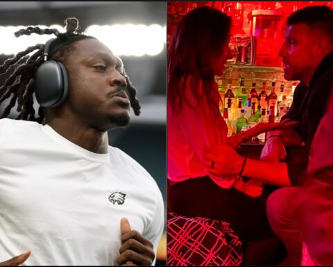 Close-up of a man wearing large over-ear headphones, looking to the side at a music event or DJ setup.