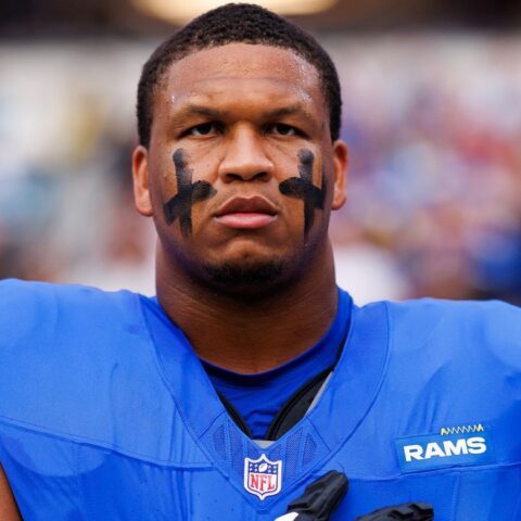 Close-up of a Rams football player wearing blue and yellow jersey with eye black, standing on the field.