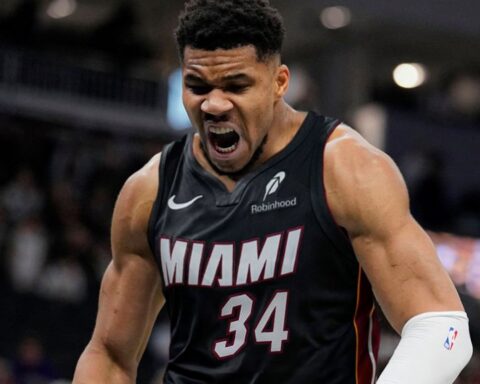 Miami Heat player in jersey #34 shouting intensely on the court during a game, muscles tensed and mouth open in a roar.