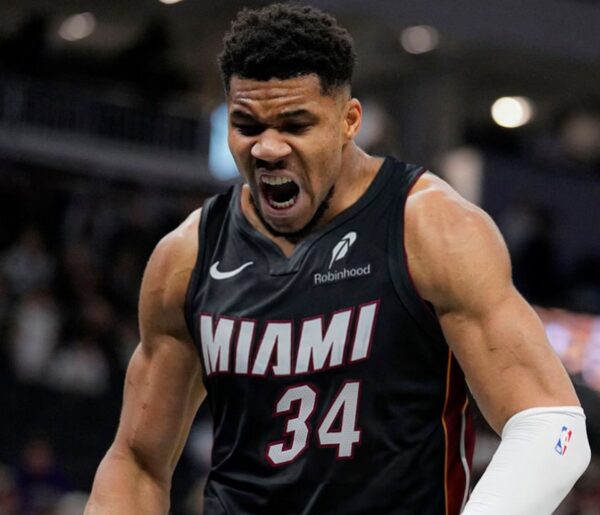 Miami Heat player in jersey #34 shouting intensely on the court during a game, muscles tensed and mouth open in a roar.