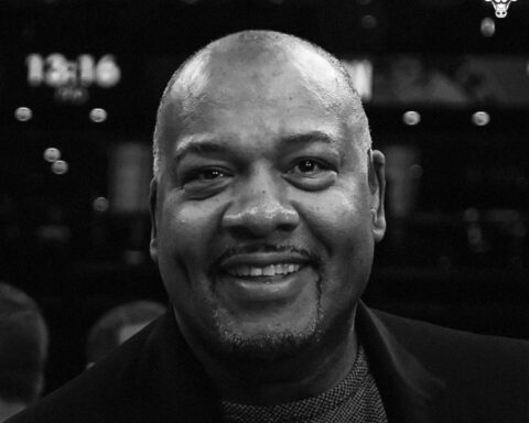 Staff headshot: smiling Black man in a dark blazer, black-and-white portrait.