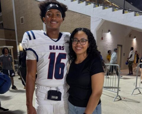 Football player in a white Bears jersey number 16 posing with a smiling woman in glasses.