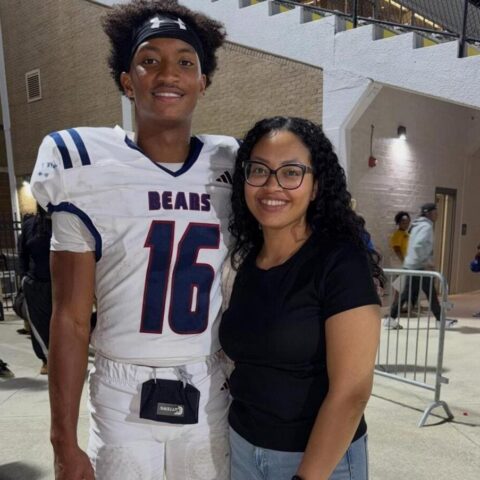 Football player in a white Bears jersey number 16 posing with a smiling woman in glasses.