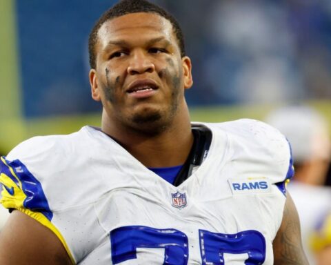 Close-up of a Los Angeles Rams football player in a white jersey with blue numbers, face paint, looking off to the side on the field.