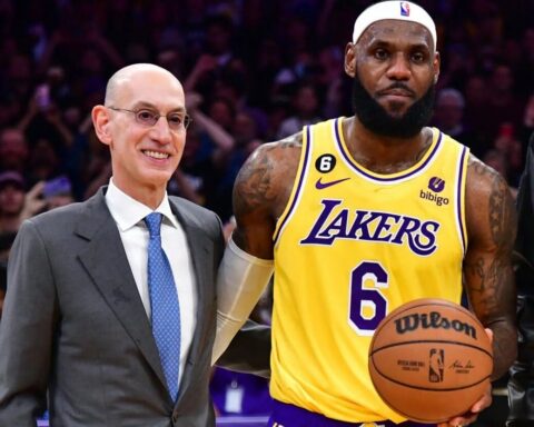 Commissioner Adam Silver standing next to LeBron James in a Lakers jersey (#6), holding a basketball during a game event.