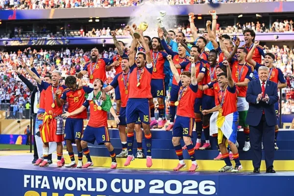 Soccer team on a podium celebrating FIFA World Cup 2026 with medals and the trophy raised high as fans cheer behind them.