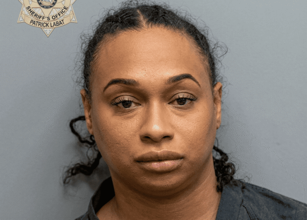 Mugshot of a woman with a neutral expression, gray background, sheriff's office badge in the top-left corner labeled Patrick Labat.